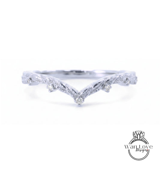 A silver ring with a v-shaped design and small diamonds set in the center.