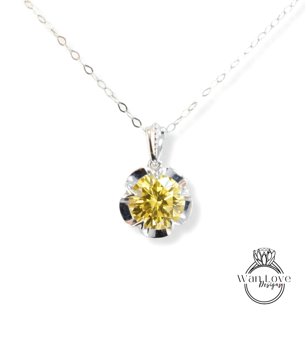 A close-up view of a yellow diamond pendant on a silver necklace.