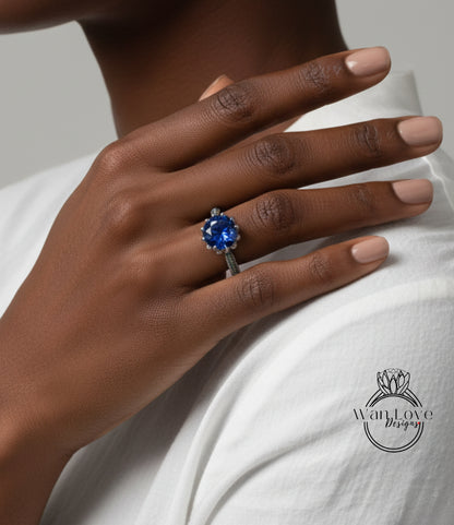A close-up of a person's hand wearing a ring with a large blue gemstone.