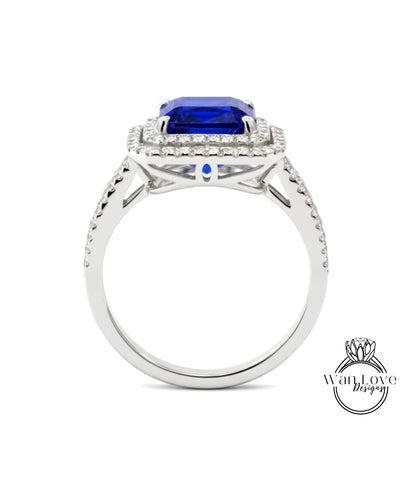 A silver ring with a large blue gemstone, likely a sapphire, set in a halo of smaller diamonds.