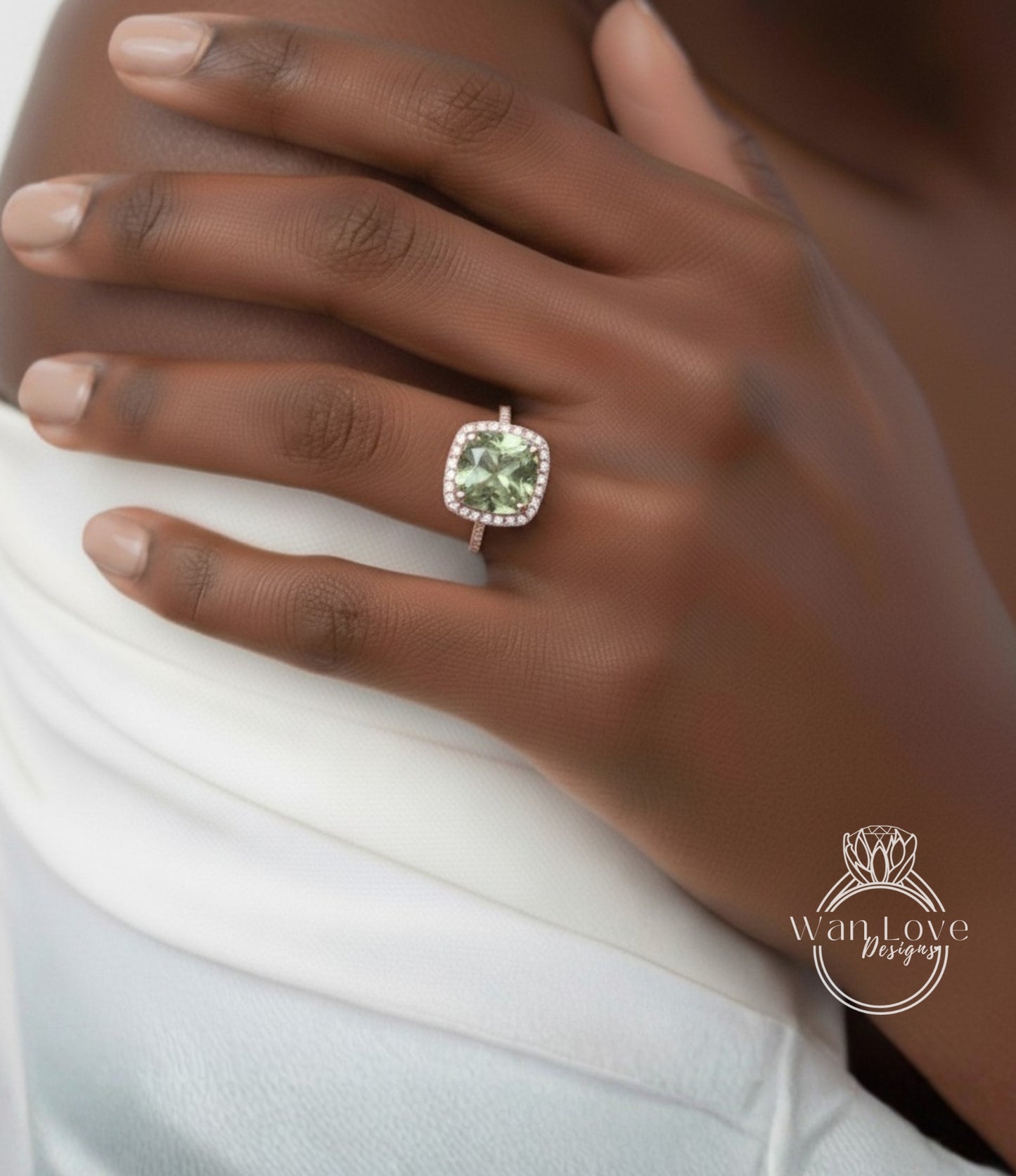 A close-up of a person's hand wearing a ring with a large, green gemstone.