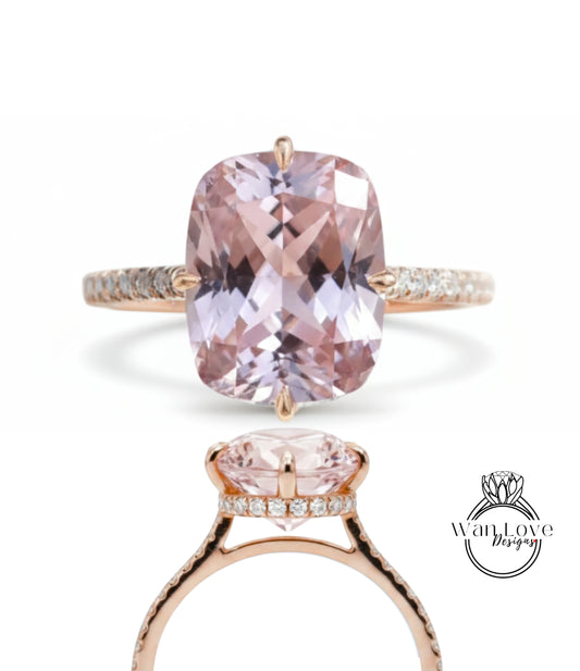 A large, pink gemstone engagement ring with a gold band and small diamonds.
