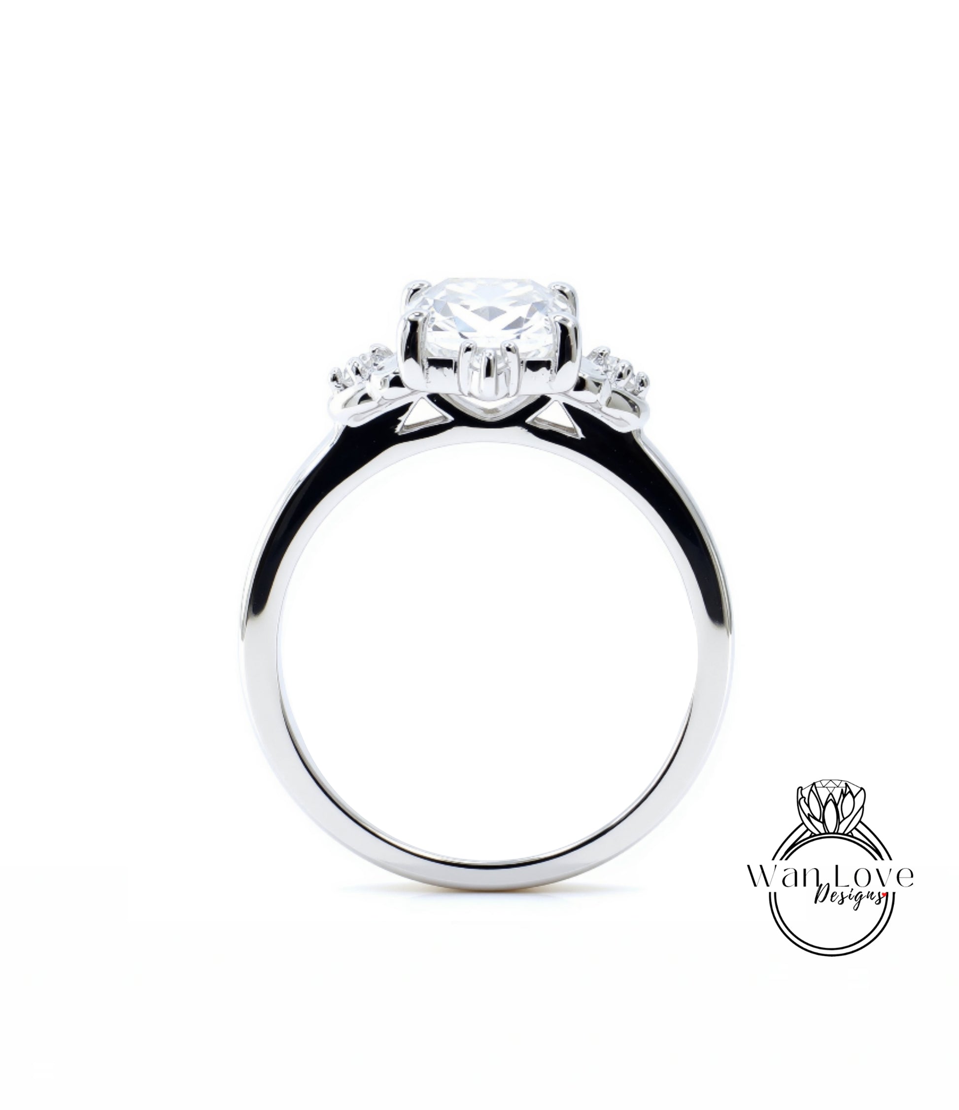A close-up view of a silver engagement ring with a large central diamond surrounded by smaller diamonds on either side.