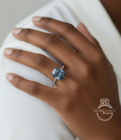 A close-up of a hand wearing a ring with a large blue gemstone.