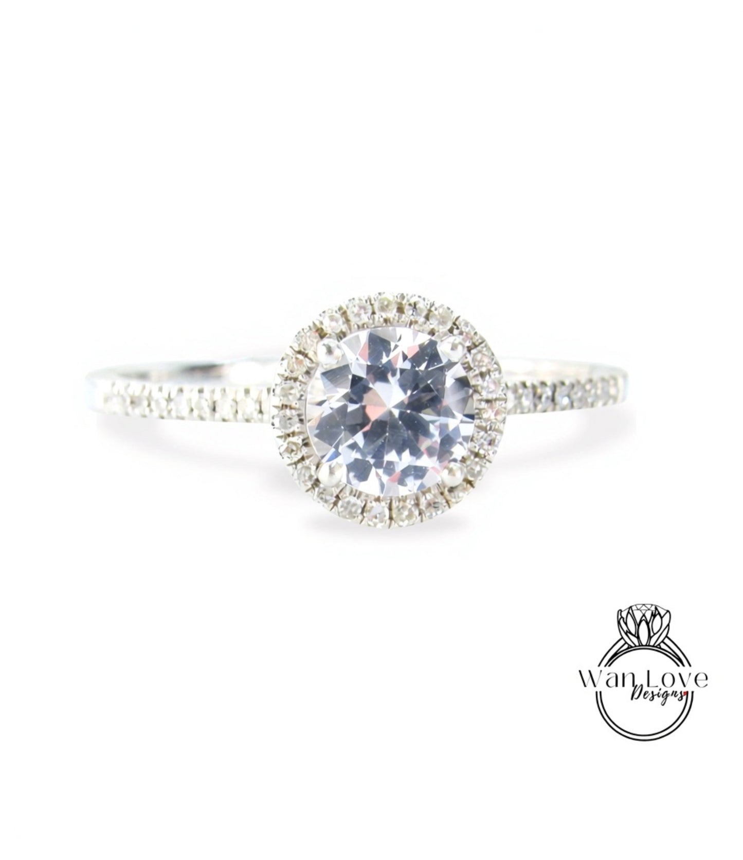 A close-up view of a diamond engagement ring with a large central diamond surrounded by smaller diamonds, set in a halo of smaller diamonds.