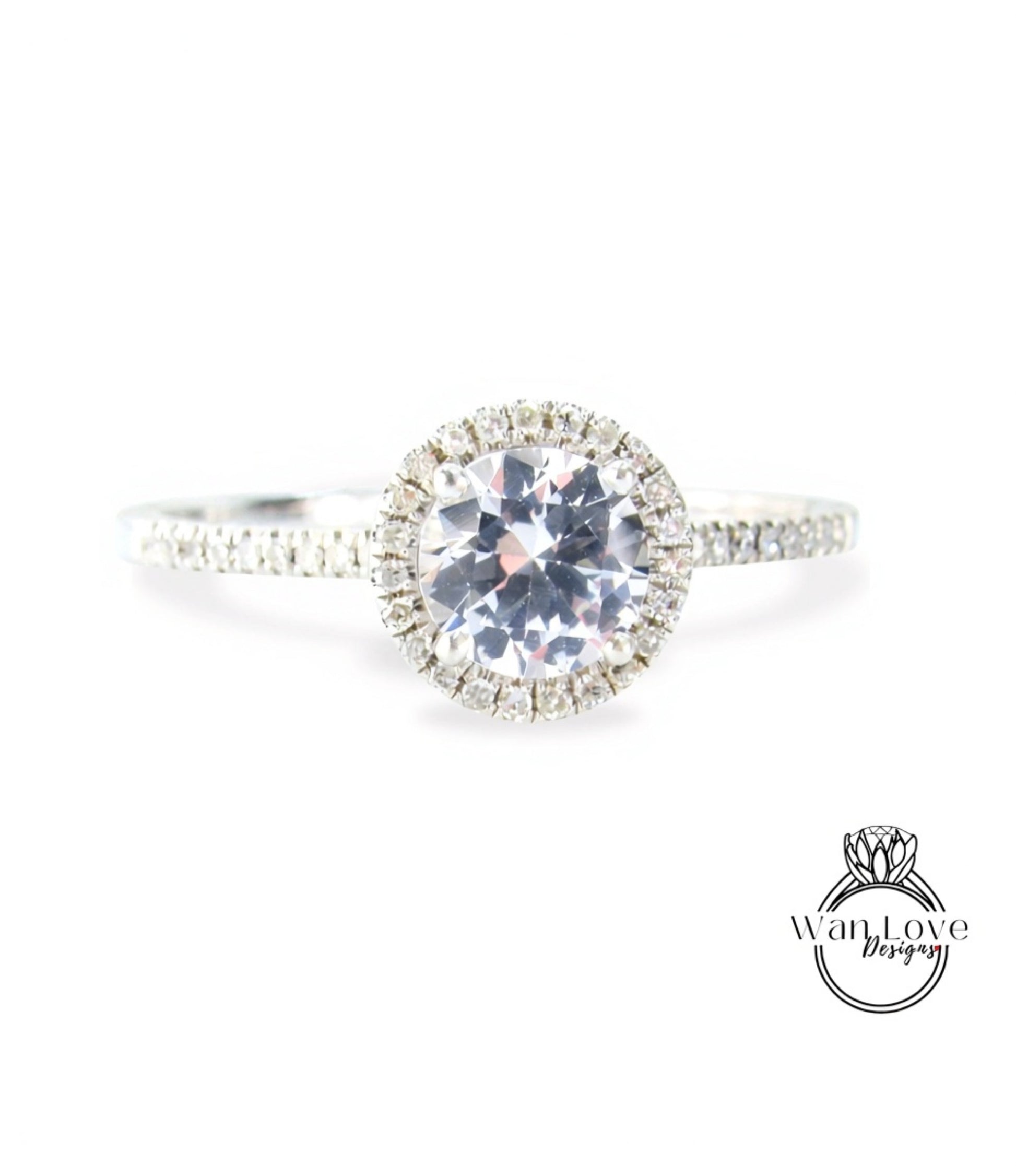 A close-up view of a diamond engagement ring with a large central diamond surrounded by smaller diamonds, set in a halo of smaller diamonds.