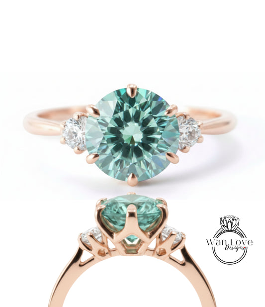 a beautiful engagement ring with a large, round, green gemstone set in a rose gold band. The ring is adorned with three smaller diamonds on either side of the large gemstone, creating a symmetrical and elegant design.
