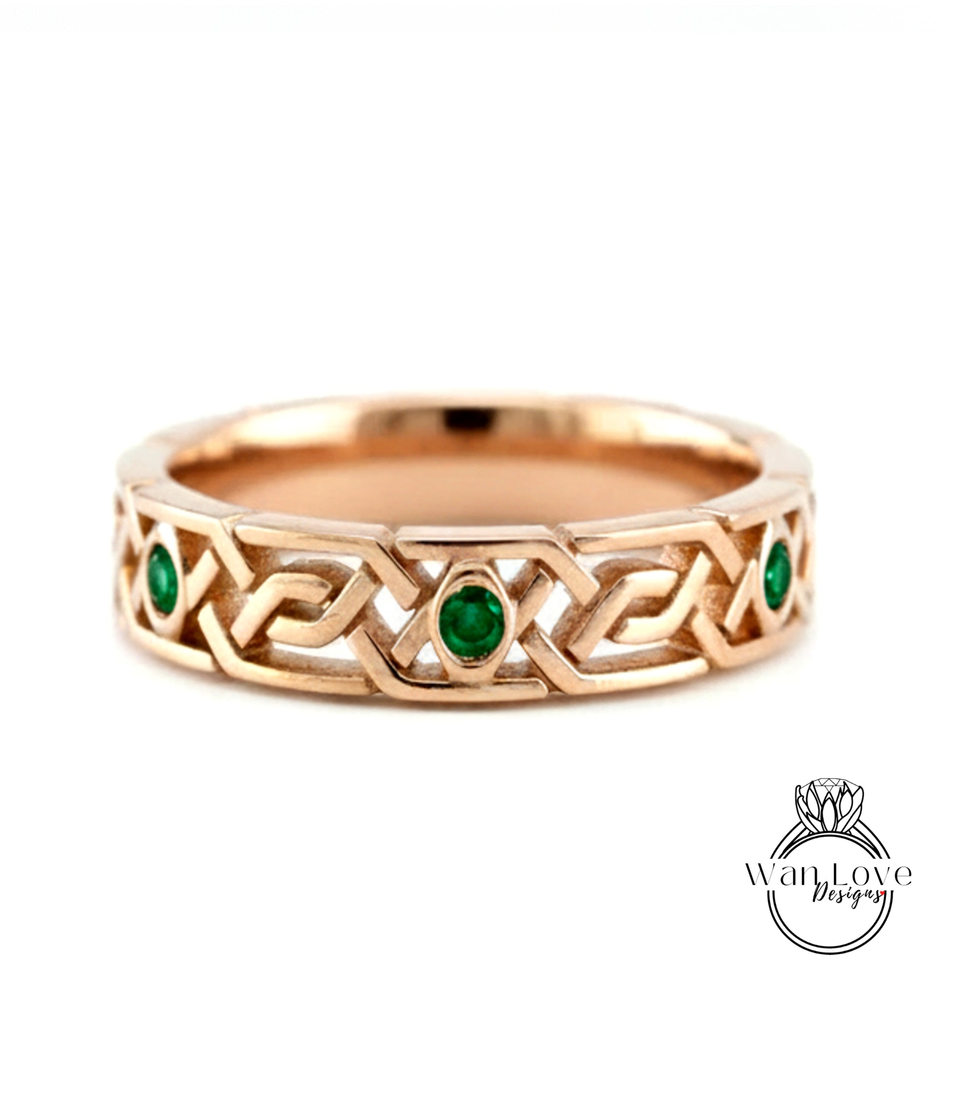 A gold ring with a Celtic knot design and two green gemstones.