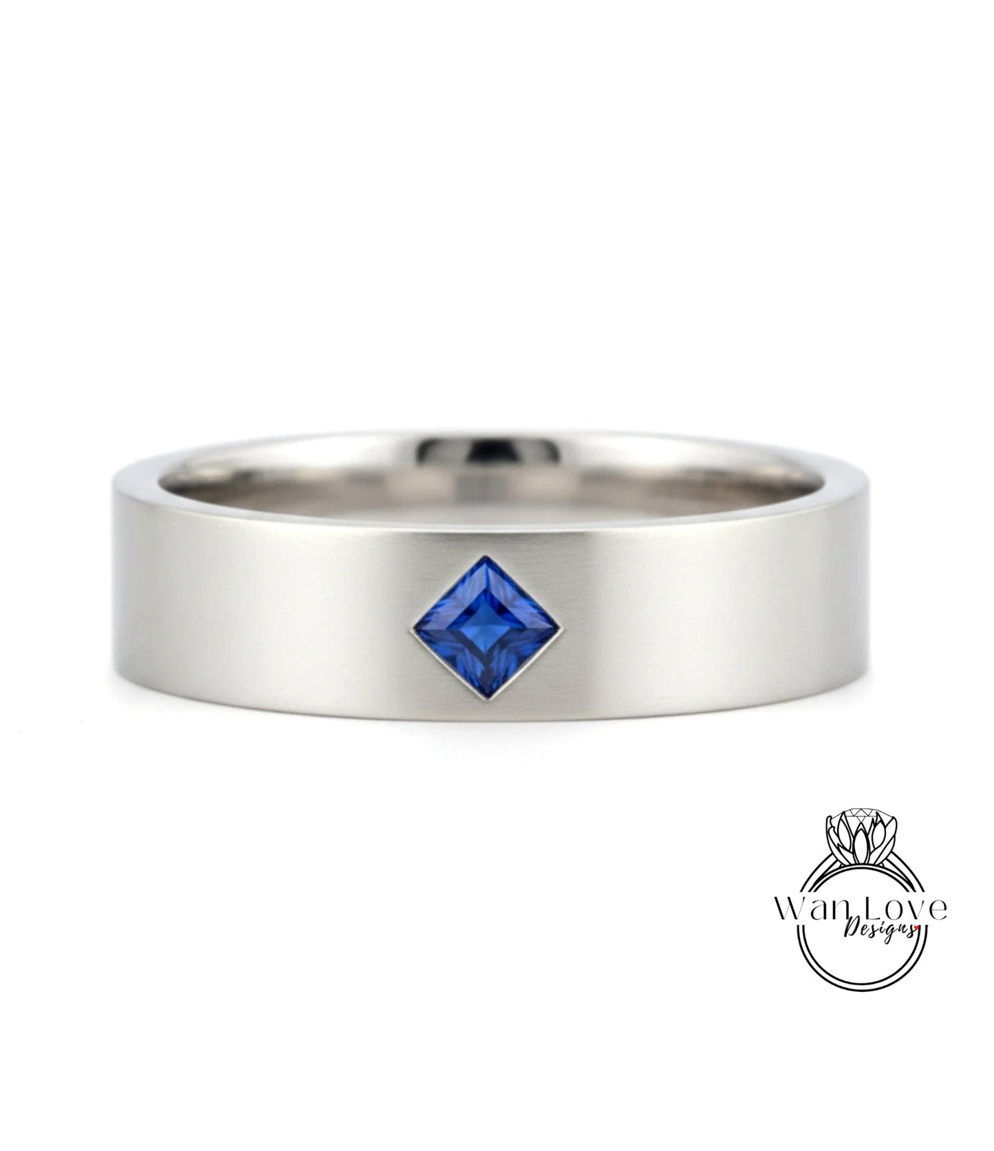 A silver ring with a blue gemstone, possibly a sapphire, set in the center.