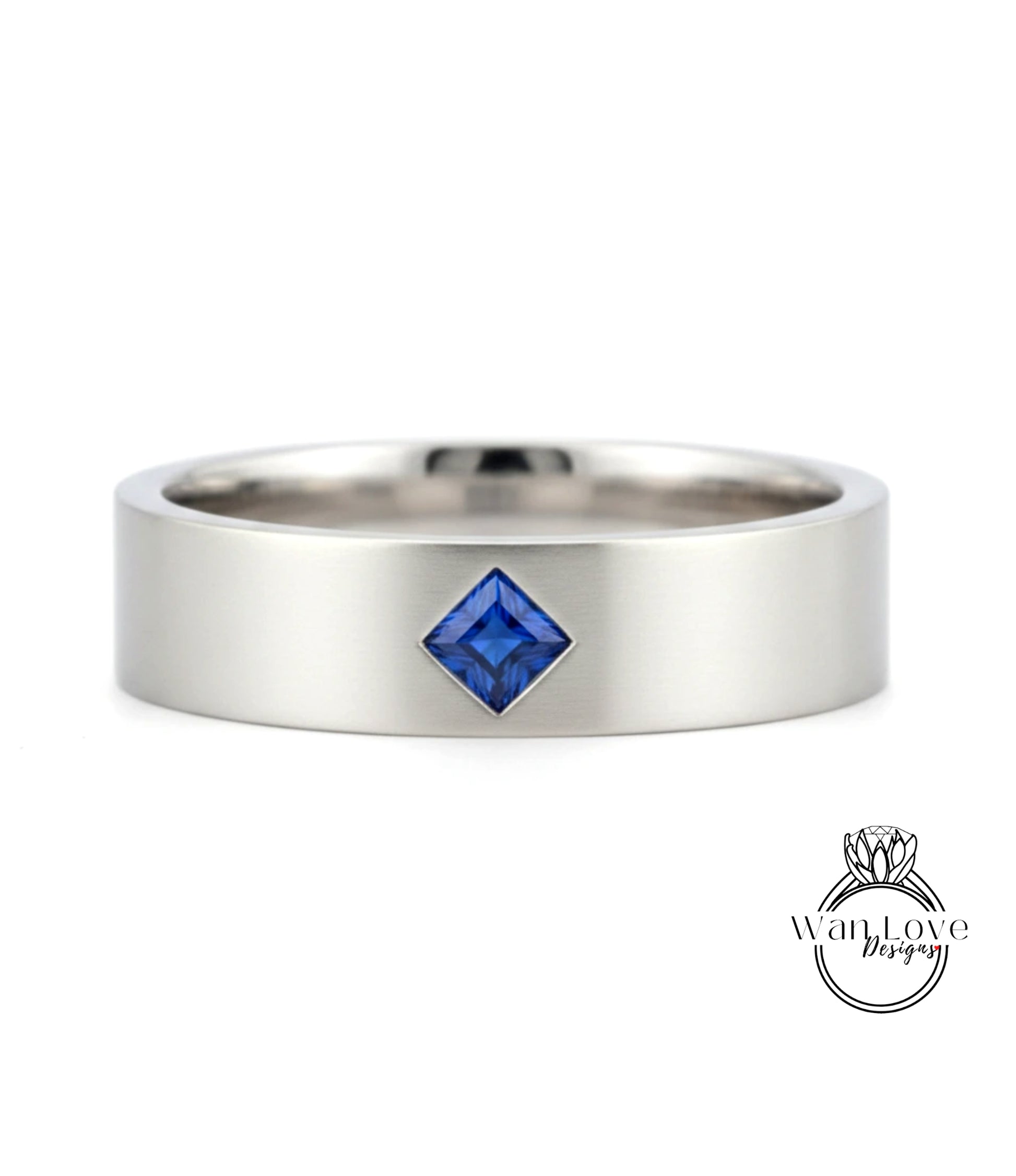 A silver ring with a blue gemstone, possibly a sapphire, set in the center.
