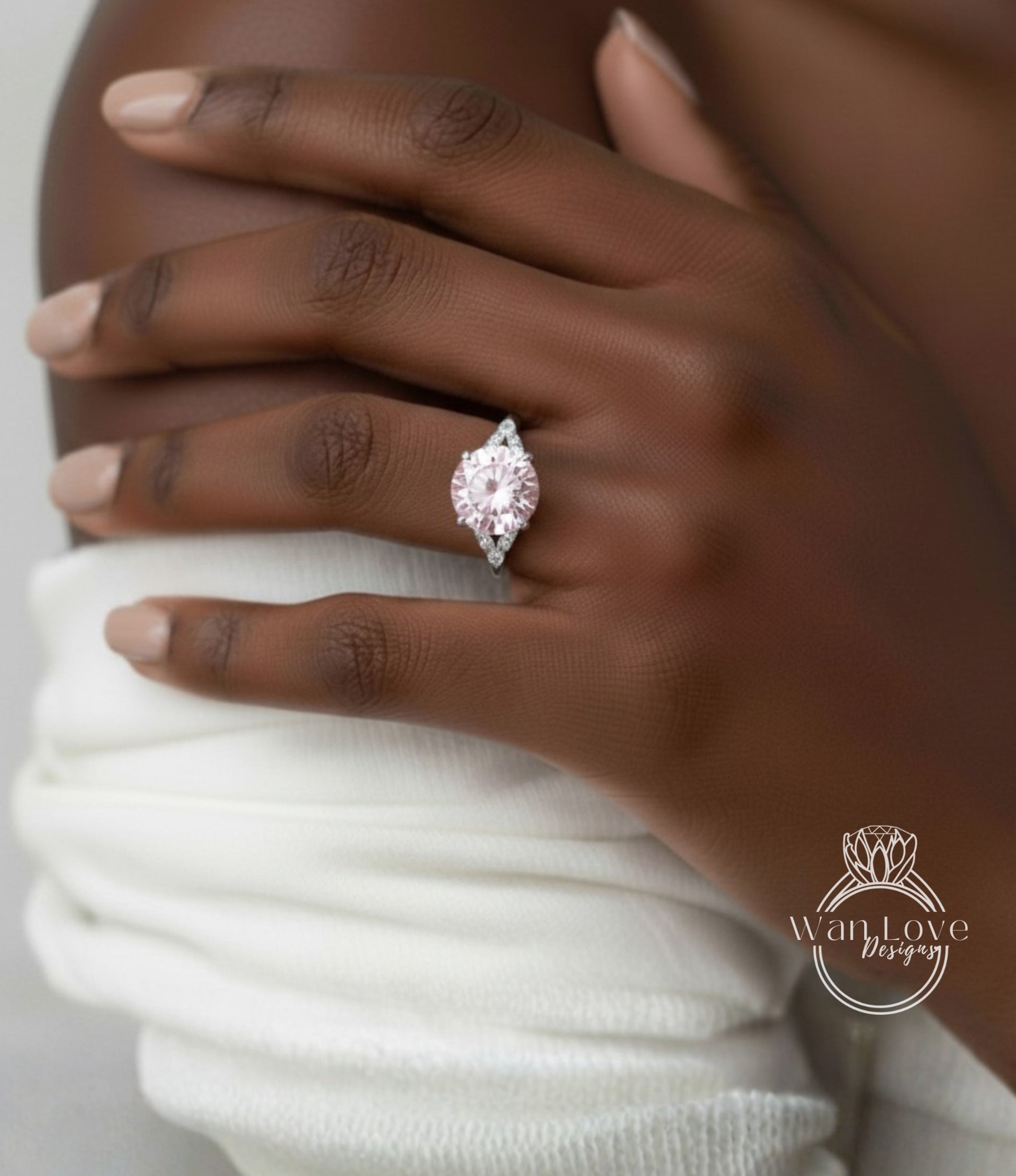 A close-up of a hand wearing a large, pink diamond engagement ring.