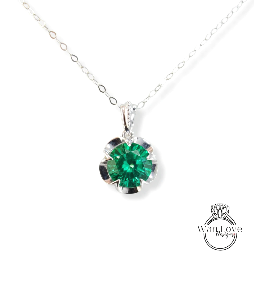 A silver necklace with a large, green gemstone pendant.