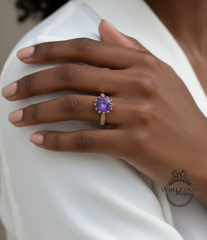 A close-up of a person's hand wearing a ring with a purple gemstone.