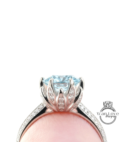 A close-up view of a diamond engagement ring with a large blue gemstone set in a silver band.