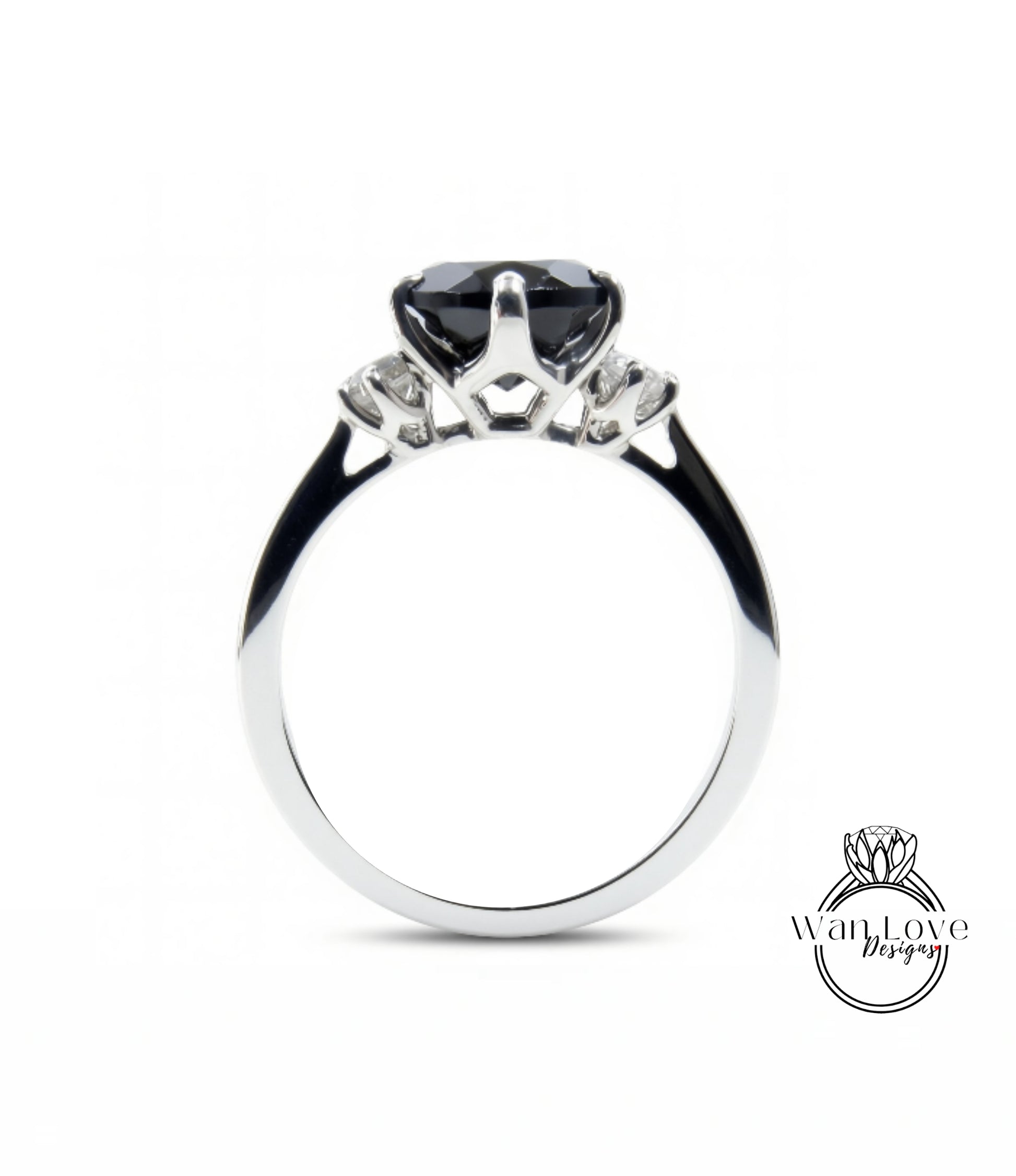 A silver engagement ring with a large black gemstone, possibly a diamond, set in the center.