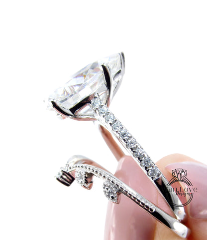 A close-up of a diamond engagement ring being held in someone's hand, showcasing the large central diamond and the intricate metalwork around it.