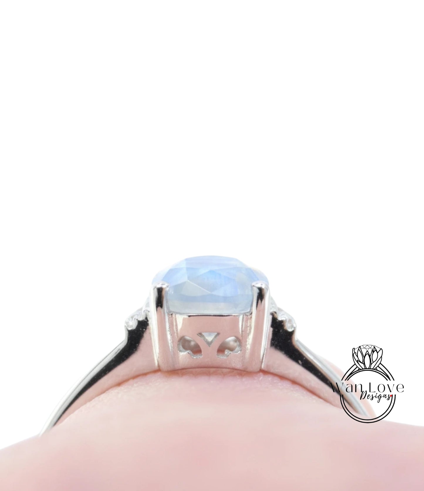 A close-up view of a silver ring with a blue gemstone, likely a sapphire, set in a halo of smaller diamonds.