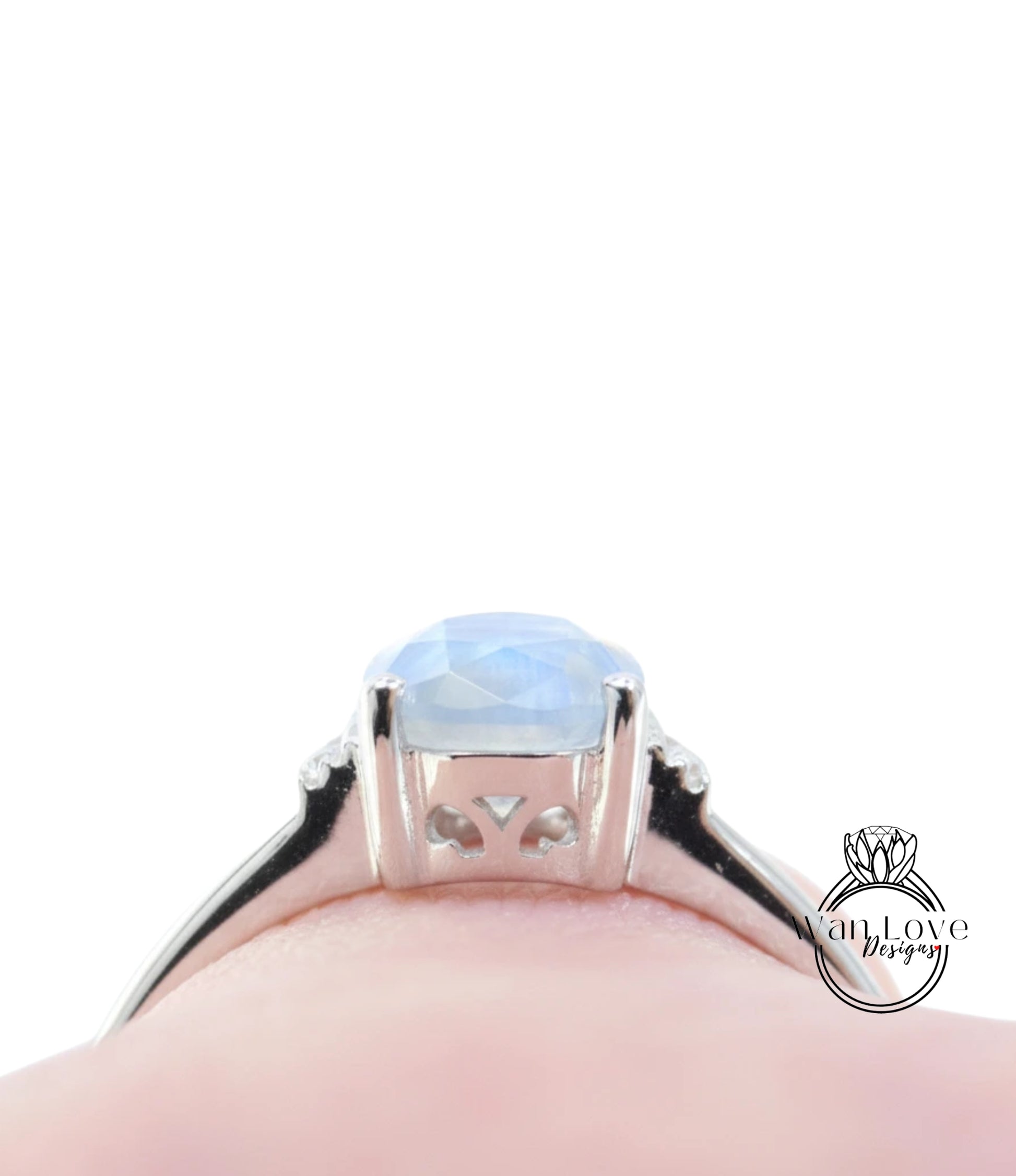 A close-up view of a silver ring with a blue gemstone, likely a sapphire, set in a halo of smaller diamonds.