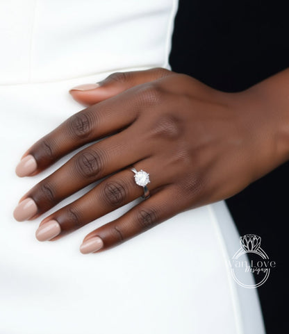 A close-up of a person's hand wearing a diamond engagement ring.