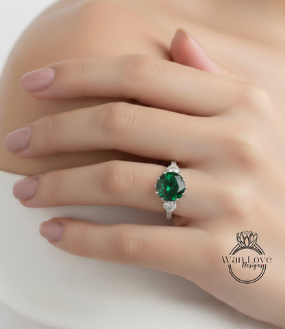 A close-up of a person's hand wearing a ring with a large green gemstone.