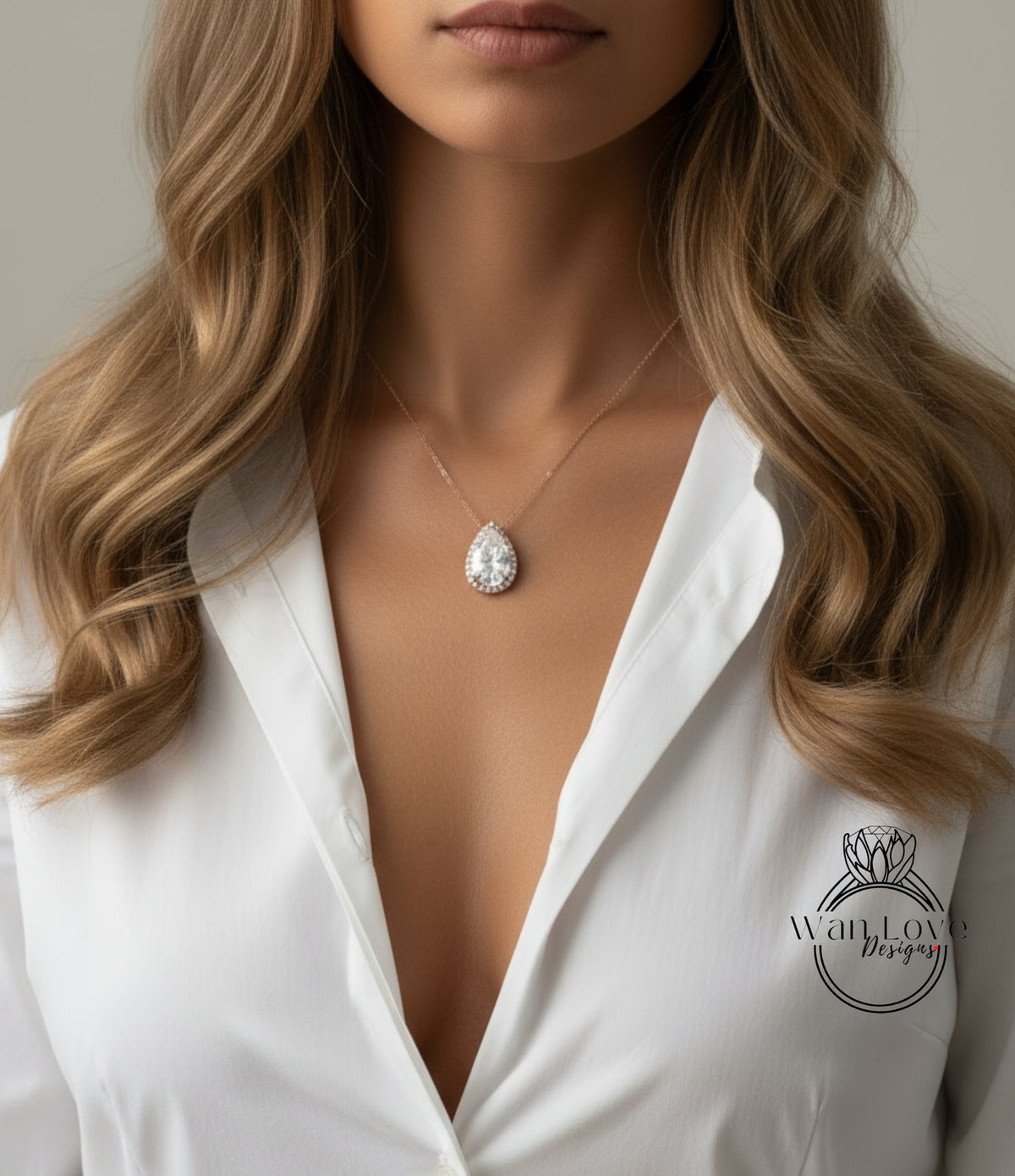 A close-up of a woman's neck and chest wearing a white blouse with a necklace featuring a large, sparkling diamond pendant.