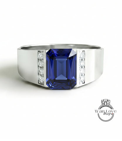 A silver ring with a large blue gemstone, likely a sapphire, set in a band with smaller diamonds.