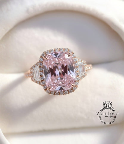 A beautiful pink gemstone ring with a halo of smaller diamonds around the center stone, displayed on a white background.