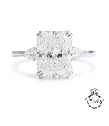 A large, brilliant-cut diamond engagement ring with a prominent central diamond surrounded by smaller diamonds on either side.