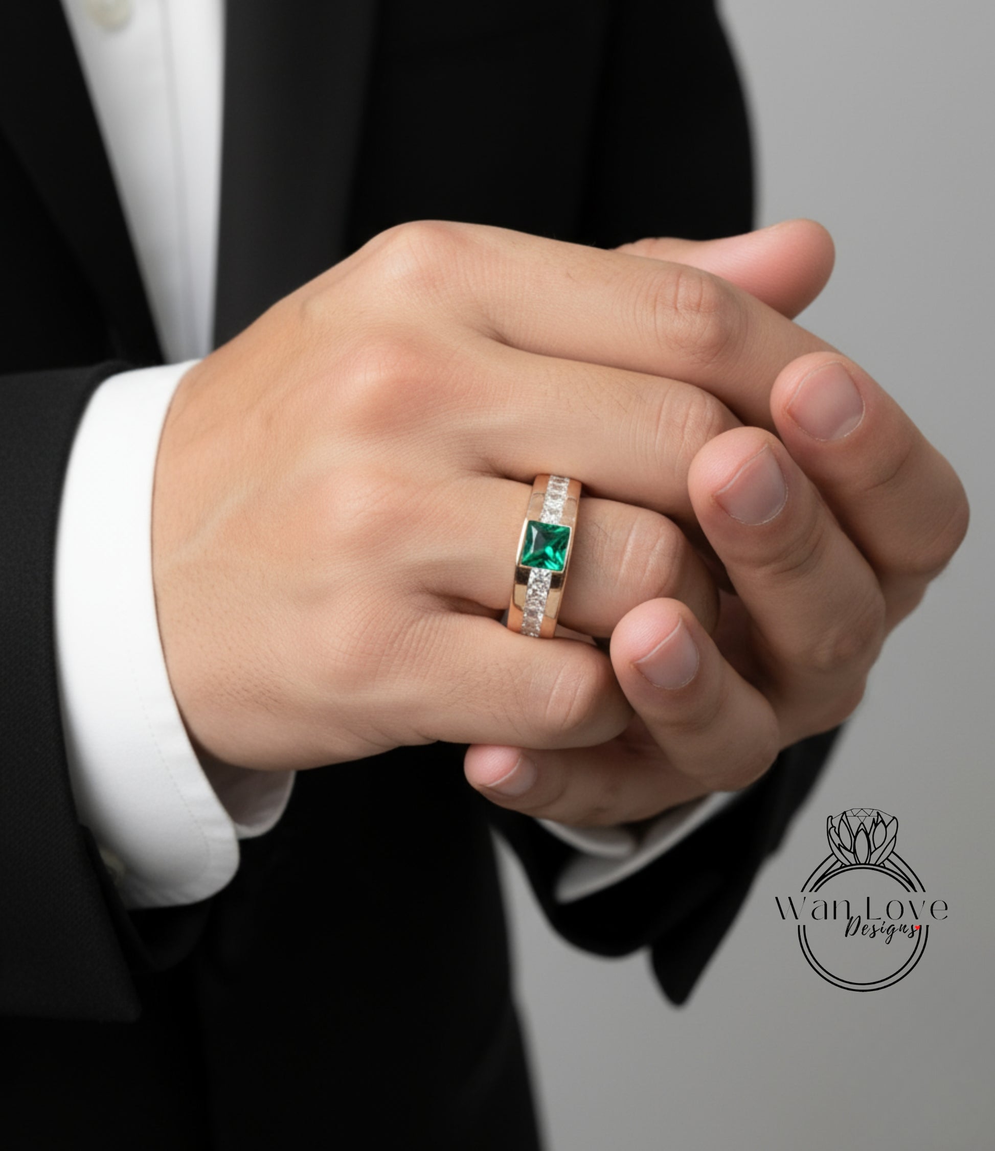 A close-up of a person's hand wearing a gold ring with a green gemstone.