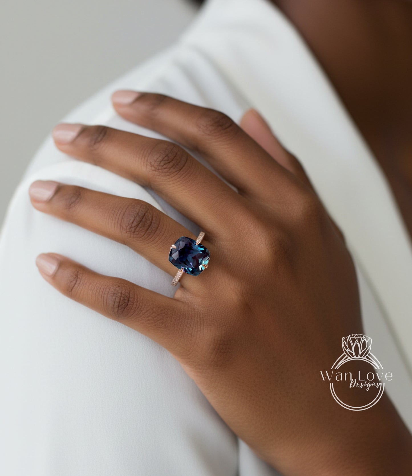 A close-up of a person's hand wearing a ring with a large blue gemstone.