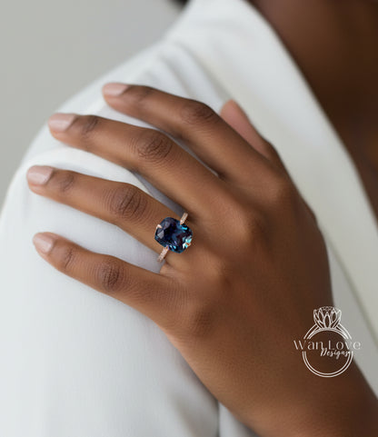 A close-up of a person's hand wearing a ring with a large blue gemstone.