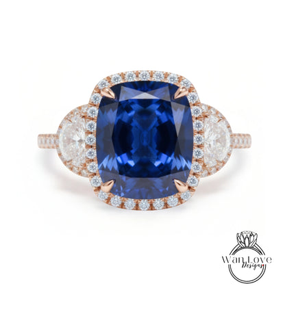 A stunning ring featuring a large, deep blue gemstone surrounded by smaller diamonds and set in a halo of smaller diamonds.