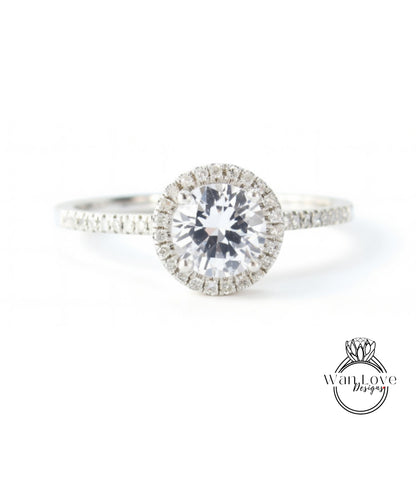 A close-up view of a diamond engagement ring with a large central diamond surrounded by smaller diamonds on the band.