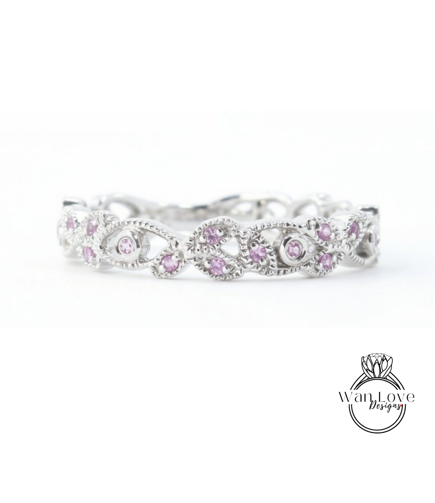 A silver ring with a decorative floral design and small purple gemstones.