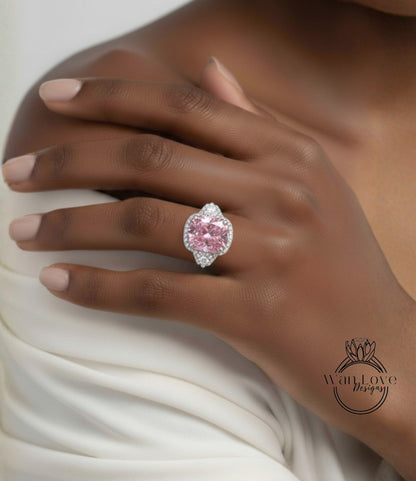 A close-up of a person's hand wearing a large, pink diamond ring.