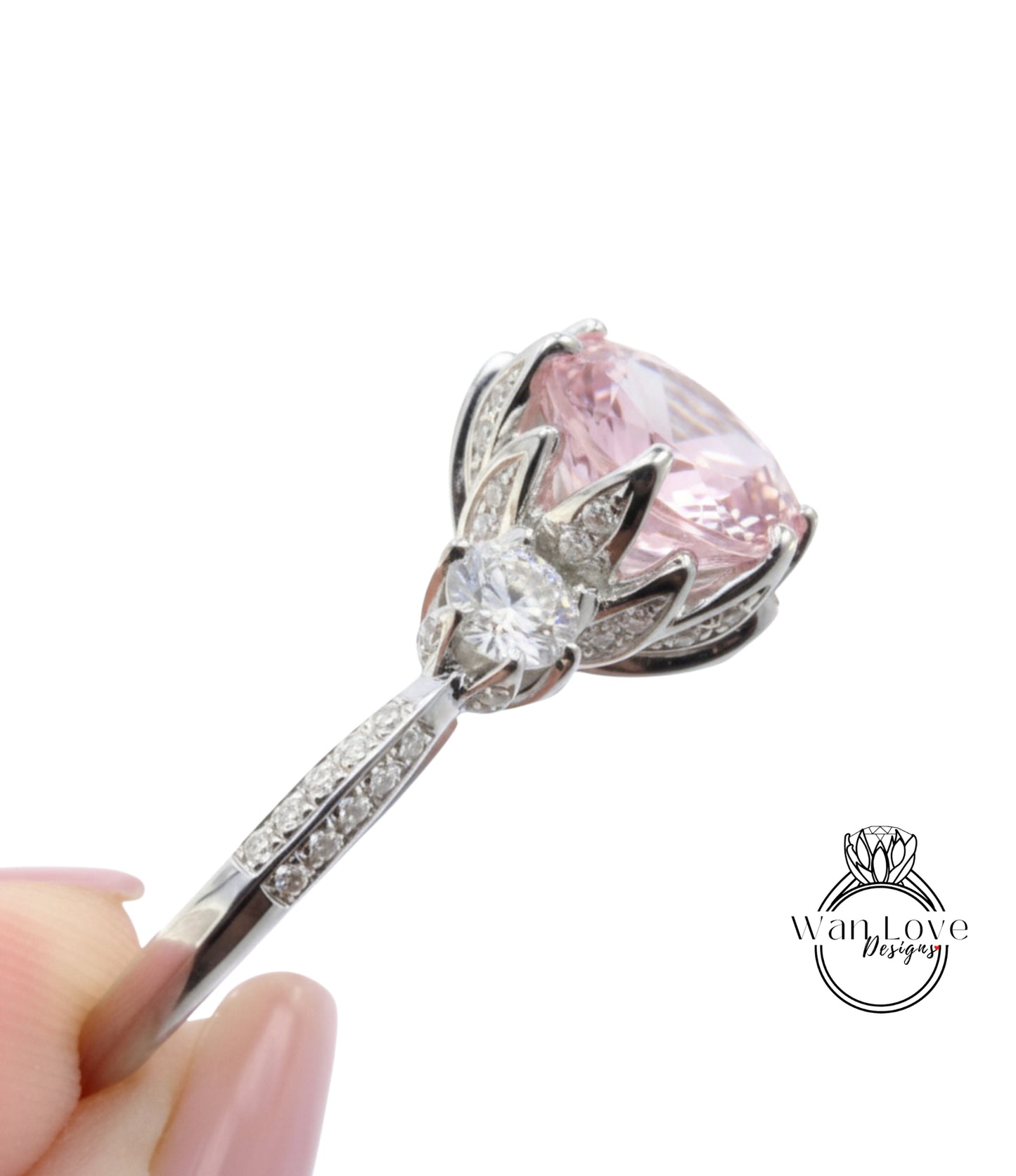 A close-up view of a diamond engagement ring with a large pink gemstone and a smaller diamond set in a silver band.