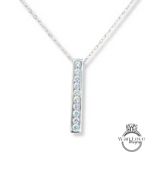A silver necklace with a rectangular pendant featuring a row of small diamonds.