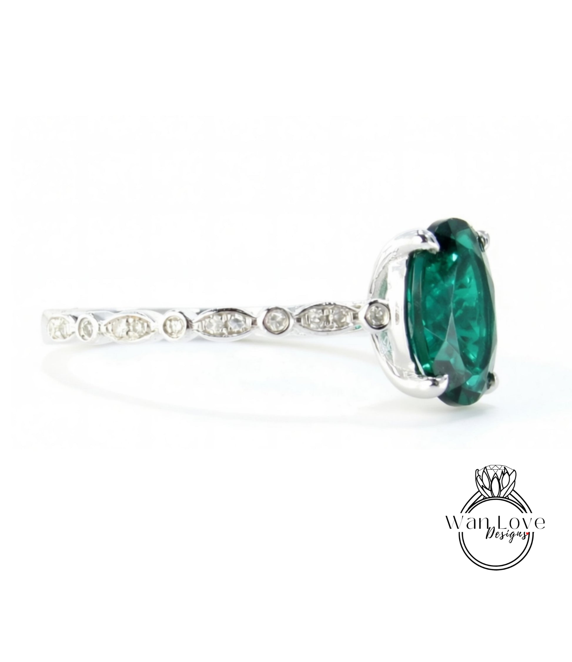 A silver ring with a large oval-shaped green gemstone, possibly a diamond, set in the center.