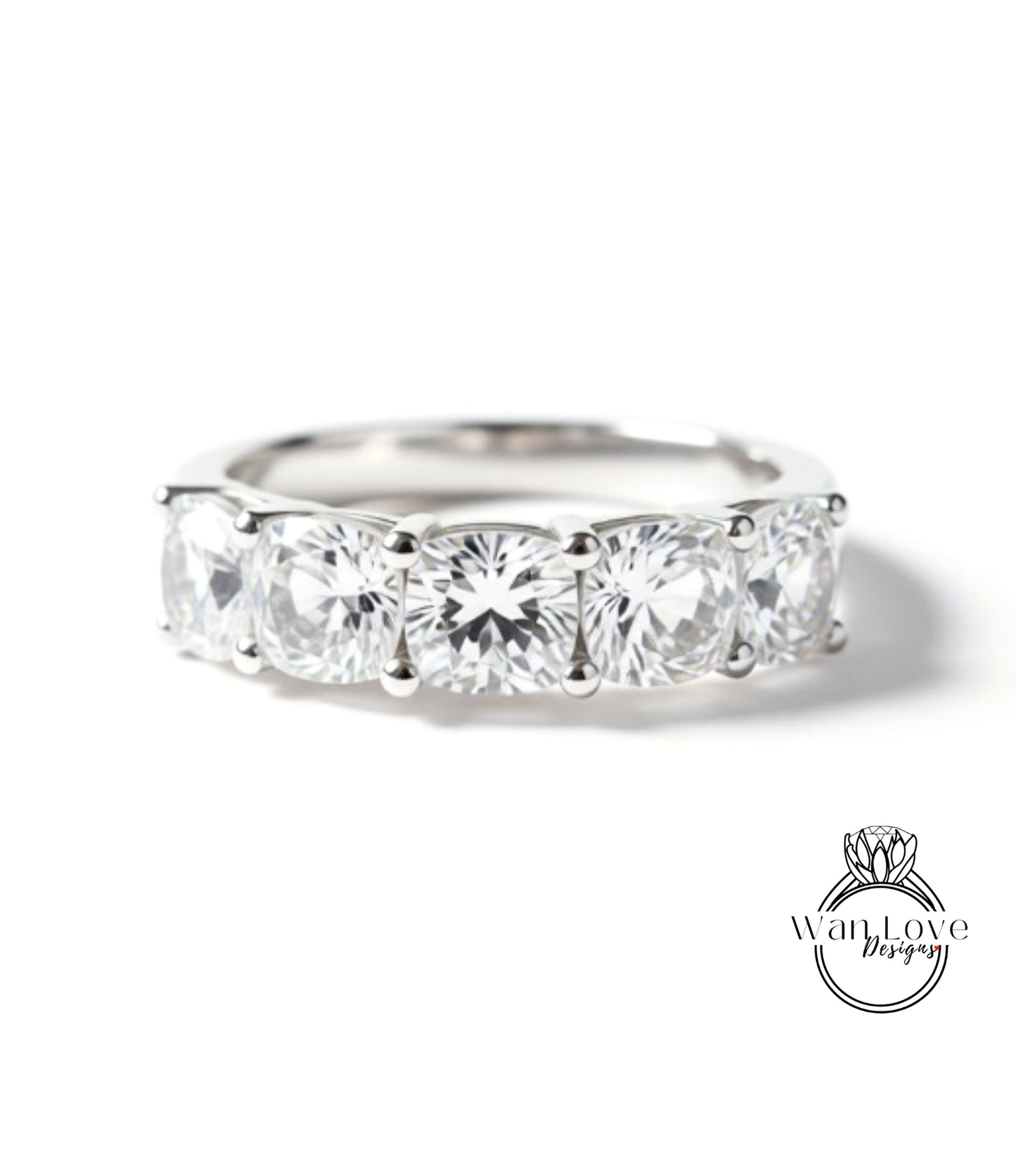 A close-up view of a silver ring with a row of four large, clear diamonds set in the band.