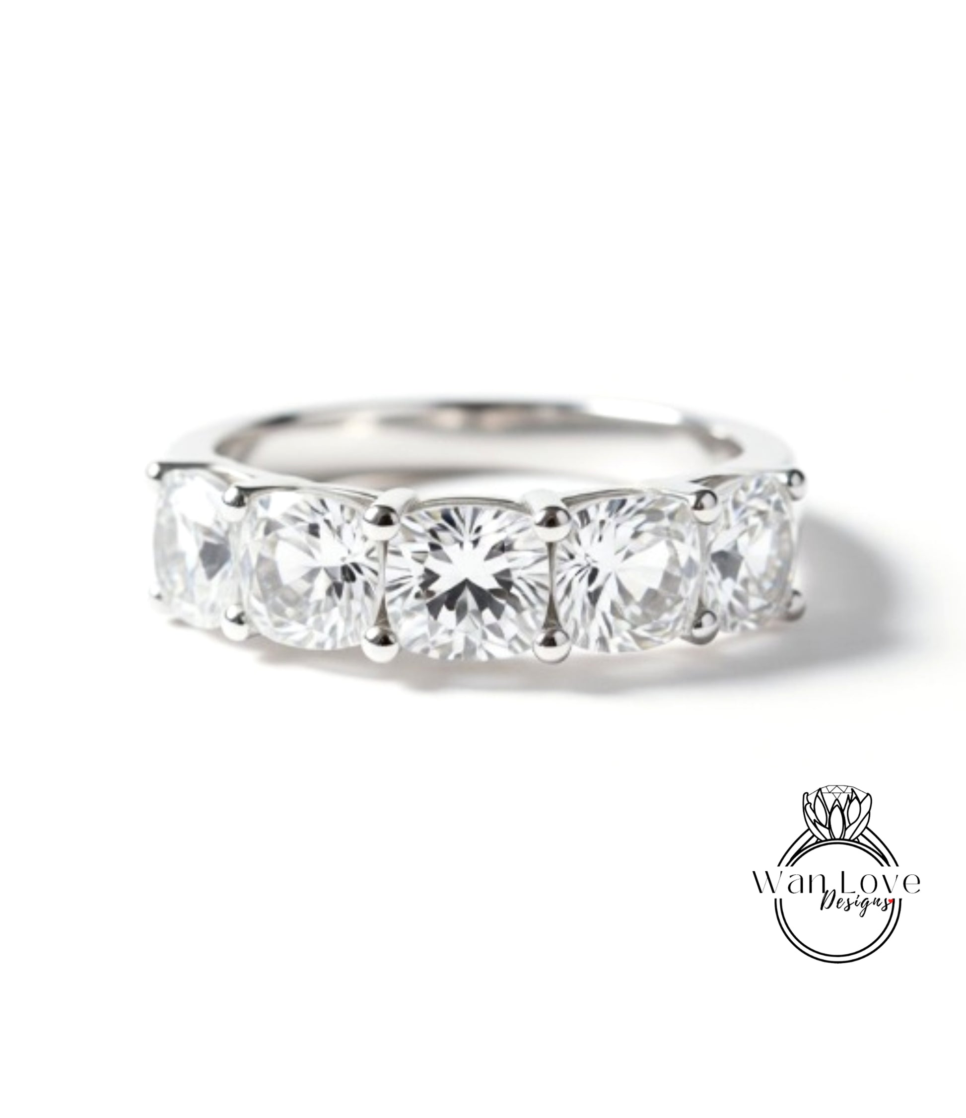 A close-up view of a silver ring with a row of four large, clear diamonds set in the band.