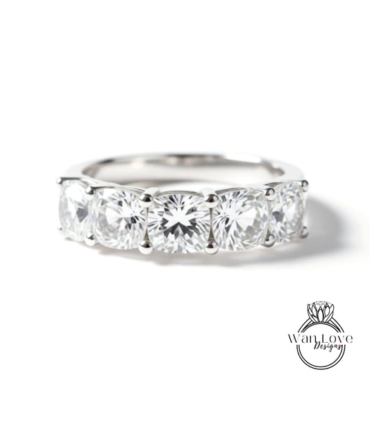 A close-up view of a silver ring with a row of four large, clear diamonds set in the band.