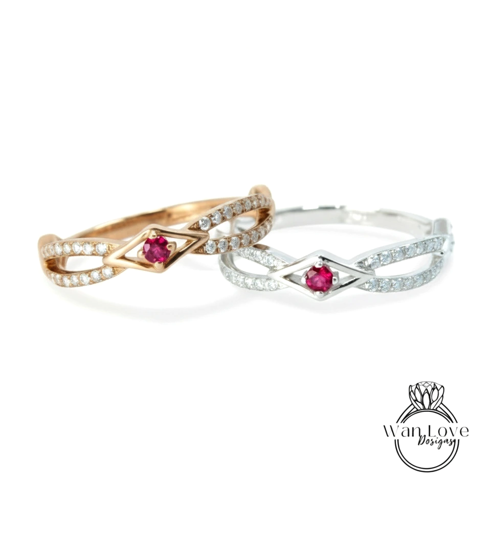two rings with gemstones, one in gold and the other in silver, both featuring a red gemstone.