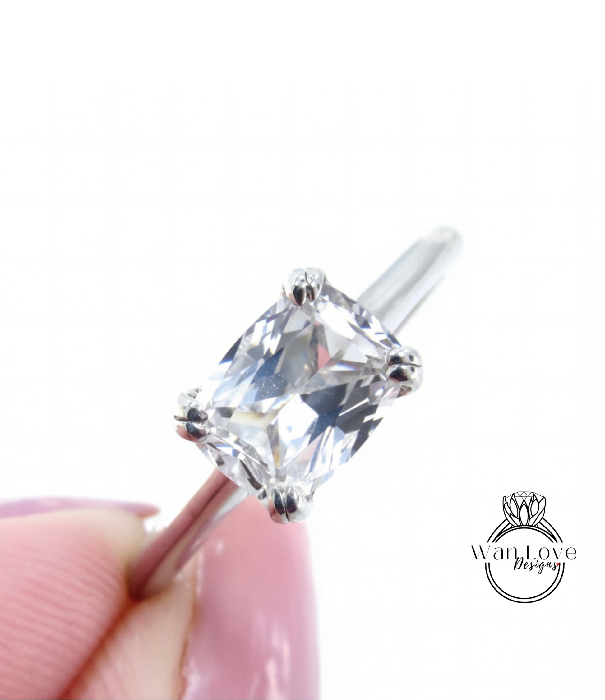 A close-up image of a diamond engagement ring being held in someone's hand, showcasing the clear gemstone and the metal band.