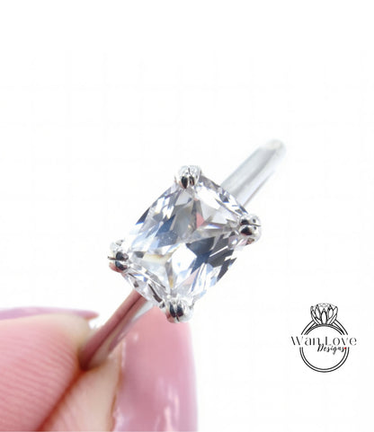 A close-up image of a diamond engagement ring being held in someone's hand, showcasing the clear gemstone and the metal band.