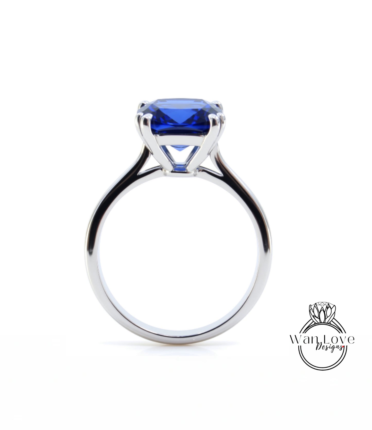 A silver ring with a large blue gemstone, likely a sapphire, set in the center.