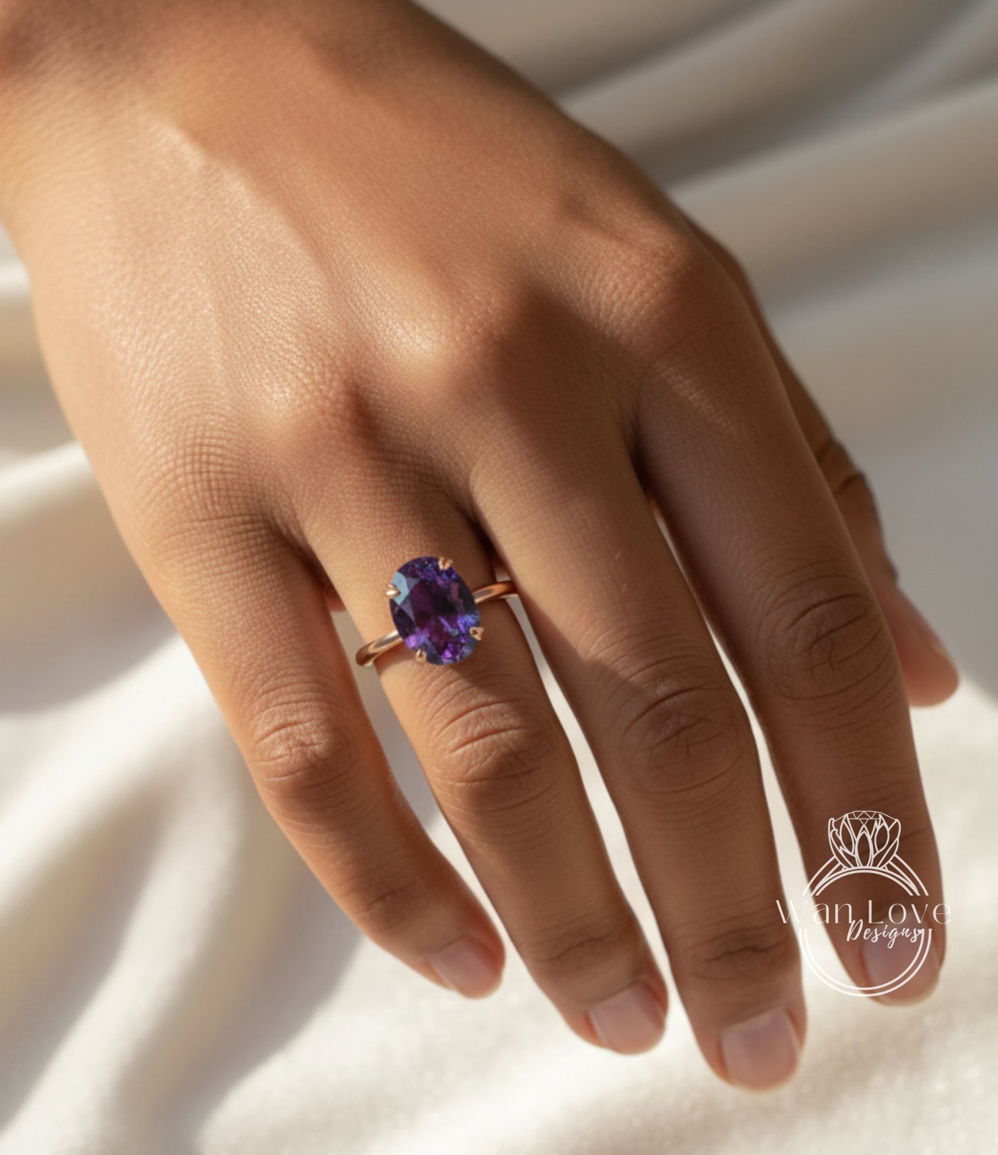 A close-up of a hand wearing a ring with a large purple gemstone.