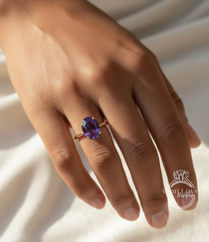 A close-up of a hand wearing a ring with a large purple gemstone.