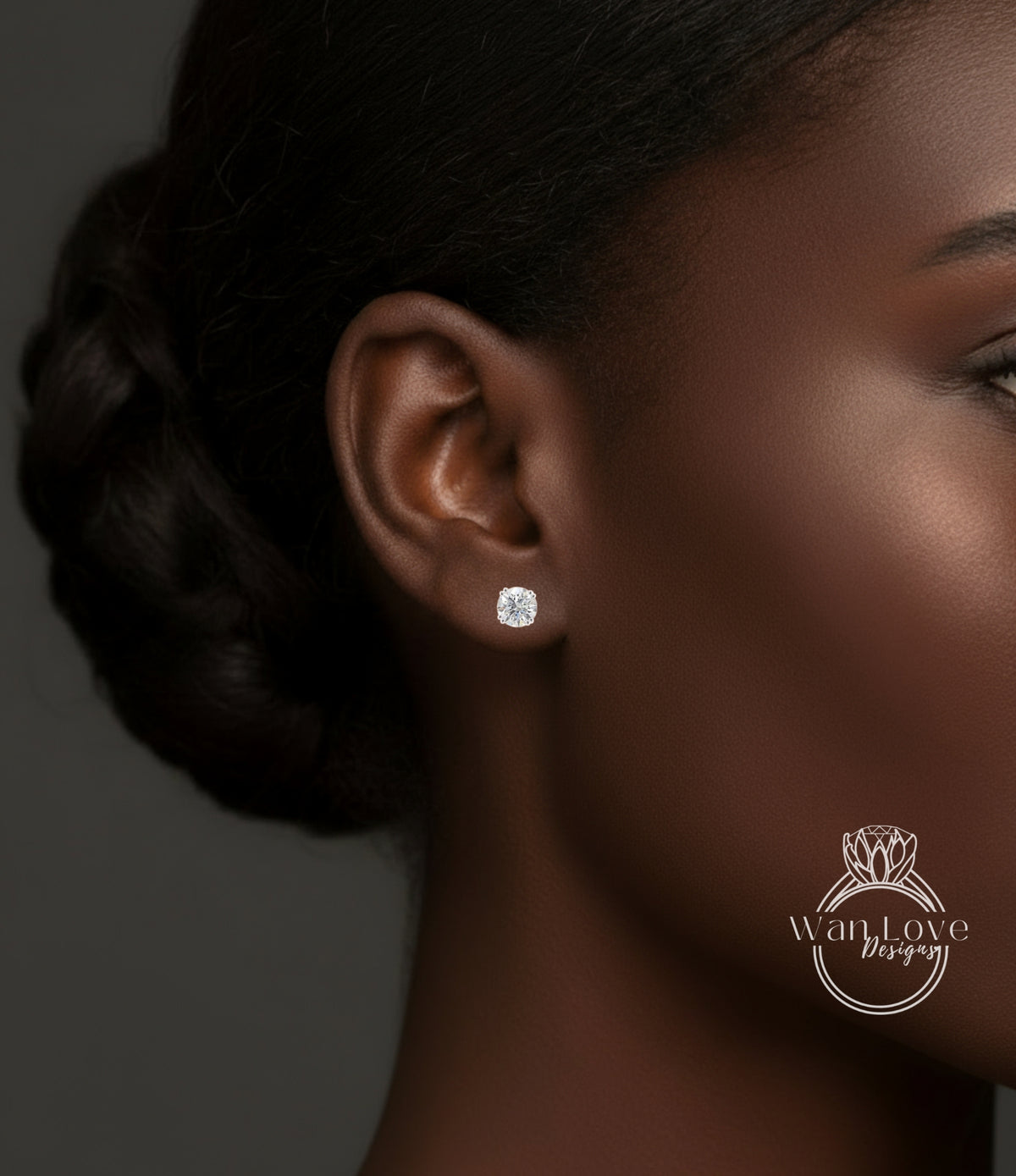 A close-up of a woman's ear with a diamond earring, showcasing the ear and the earring itself.