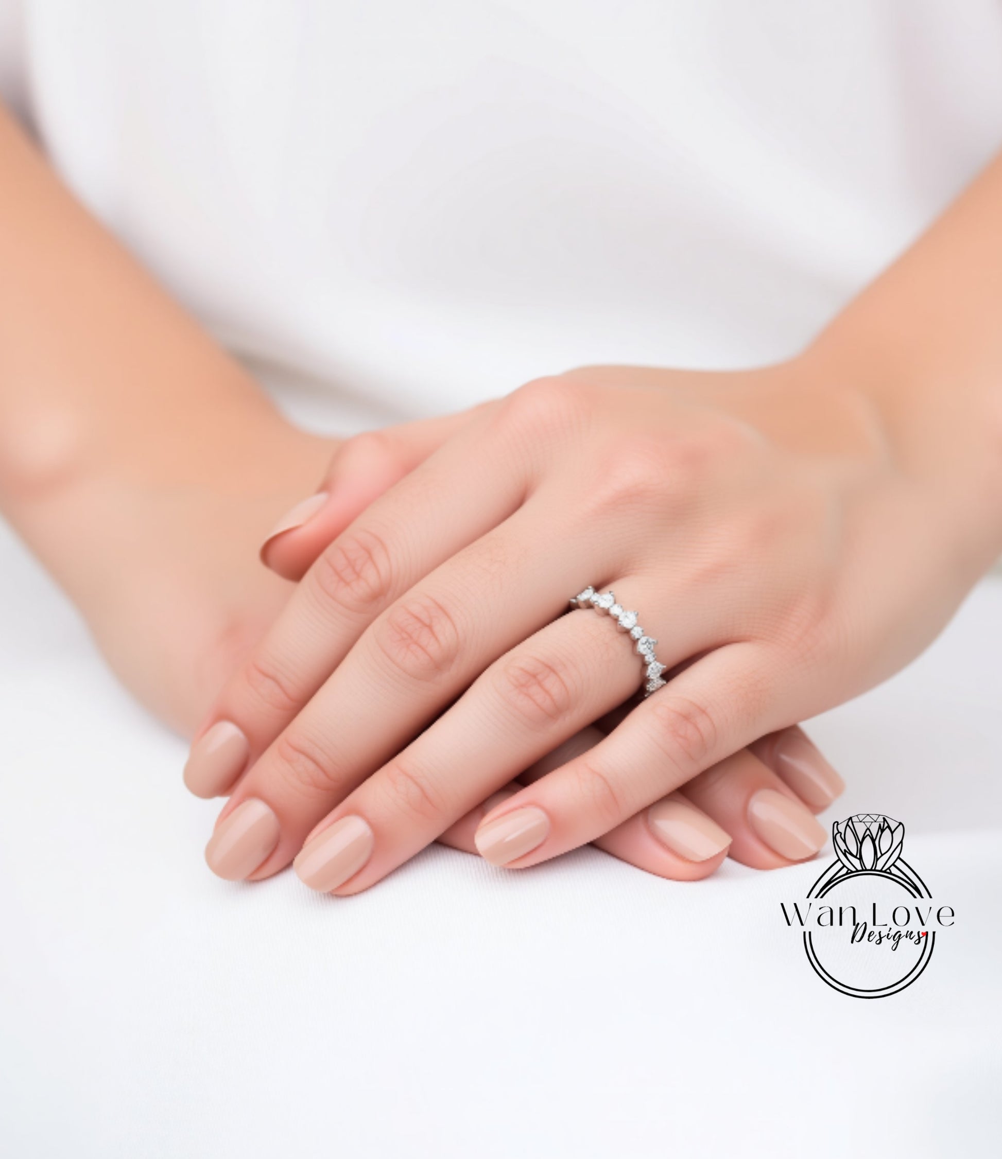 A close-up image of a person's hands wearing a diamond ring.