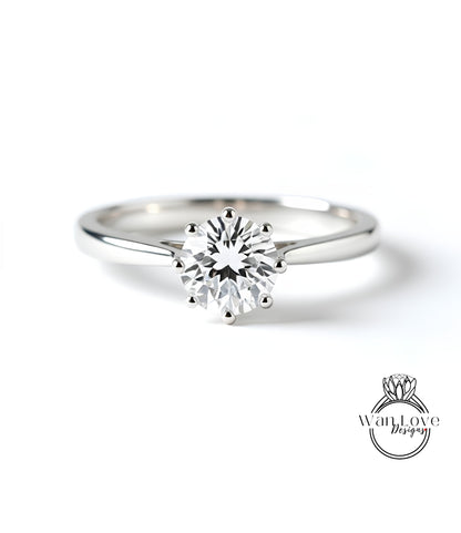 A close-up of a diamond engagement ring with a large central diamond surrounded by smaller diamonds.